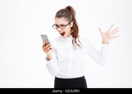 Infastiditi isterico young business woman in bicchieri parlando al cellulare e urlando su sfondo bianco Foto Stock