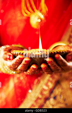 1 indian donna adulta sposa Diwali Festival a mani cupped Diya mostra Foto Stock