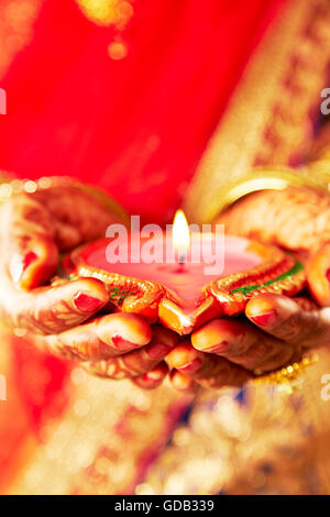 1 indian donna adulta sposa Diwali Festival a mani cupped Diya mostra Foto Stock