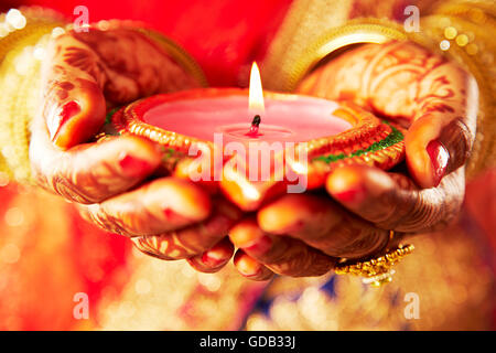 1 indian donna adulta sposa Diwali Festival a mani cupped Diya mostra Foto Stock