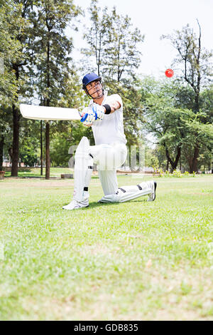 1 indian giovane cricketer giocare a cricket colpendo palla in gioco Foto Stock