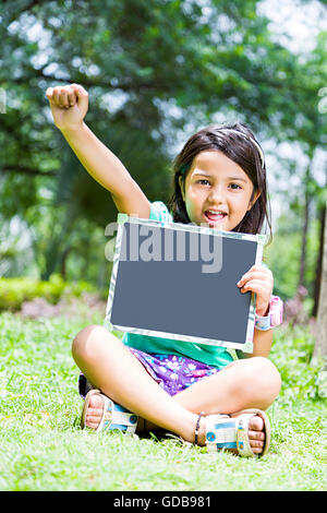 1 Kid indiano una studentessa park scheda di ardesia che mostra Foto Stock