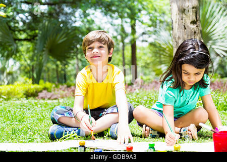 2 bambini indiani ragazzo e una ragazza amici studenti parco pittura disegno Foto Stock