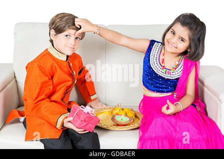 2 bambini indiani del fratello e sorella Raksha Bandhan Festival applicando Tika Foto Stock