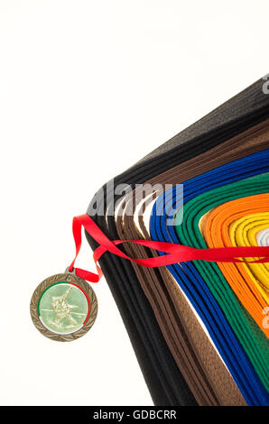 Nastri colorati in arti marziali e una parte del judo uniforme e medaglia Foto Stock