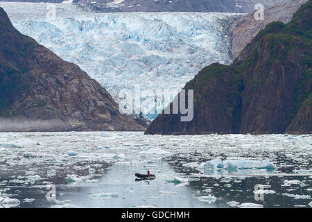 Uomo in barca nella parte anteriore del Sawyer ghiacciaio al Tracy bracci di fiordi in Alaska Stati Uniti. Foto Stock