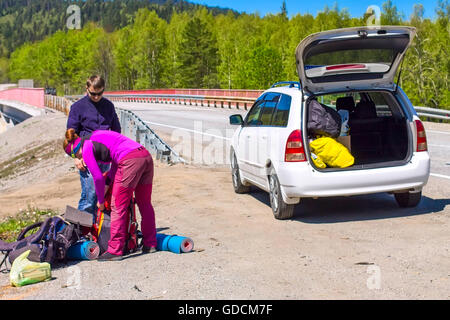 Driver download aiuta hitchhiker donna zaino in bianco auto Foto Stock