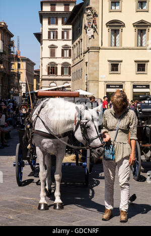 Signora con il cavallo e la spesa in Piazza San Giovanni in attesa di clienti per escursioni nei dintorni di Firenze, Toscana, Italia Foto Stock