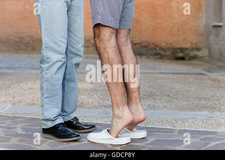 Di affetto tra due uomini, visto in un modo discreto attraverso la posizione delle loro gambe, proteso verso ogni altro come nella iconografia classica del bacio Foto Stock