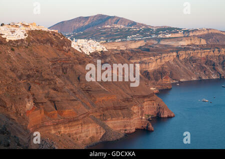 Santorini al tramonto, Case di villaggi di Firostefani e Fira affacciato sulla Caldera Foto Stock