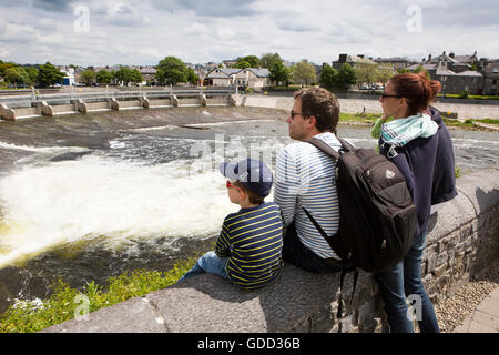 Irlanda, Co Galway, Galway, famiglia guardare i pescatori pesca al salmone Weir sul fiume Corrib Foto Stock