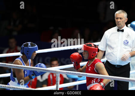 Devi Laishram dell India (rosso) compete contro Maria Machongua del Mozambico (blu) in campo femminile semifinale di peso leggero boxing (57-60kg) Concorrenza al 2014 giochi del Commonwealth a Glasgow. Devi Laishram dell India è andato sul vincere lo scontro. Foto Stock