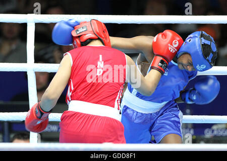 Devi Laishram dell India (rosso) compete contro Maria Machongua del Mozambico (blu) in campo femminile semifinale di peso leggero boxing (57-60kg) Concorrenza al 2014 giochi del Commonwealth a Glasgow. Devi Laishram dell India è andato sul vincere lo scontro. Foto Stock