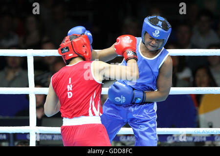 Devi Laishram dell India (rosso) compete contro Maria Machongua del Mozambico (blu) in campo femminile semifinale di peso leggero boxing (57-60kg) Concorrenza al 2014 giochi del Commonwealth a Glasgow. Devi Laishram dell India è andato sul vincere lo scontro. Foto Stock