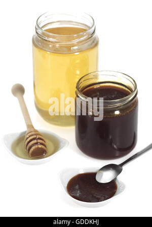 La melassa e honey pots contro uno sfondo bianco Foto Stock