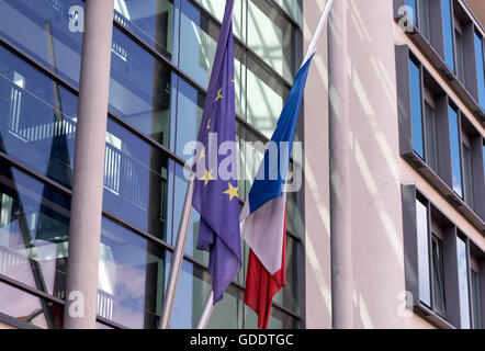 Monaco di Baviera, Germania. Il 15 luglio 2016. Un francese di bandiera nazionale (R) e un'Unione europea (UE) bandiera a mezz asta sopra la porta di ingresso al Consolato Francese generale a Monaco di Baviera, Germania, il 15 luglio 2016. Secondo i rapporti, almeno 80 morti e molti feriti dopo un carrello guidato nella folla sul famoso Promenade des Anglais durante le celebrazioni del Giorno della Bastiglia a Nizza, fine 14 luglio. Foto: SVEN HOPPE/dpa/Alamy Live News Foto Stock