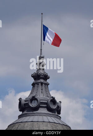 Parigi, Francia. Il 15 luglio 2016. Nazionale francese batte bandiera a mezz' asta per la costruzione del BHV Marais store a Parigi, Francia, 15 luglio, 2016. Il numero di morti sale a 84 da un attacco in cui un camion conficcata in una folla di marcatura francese la giornata nazionale di Nizza. Il Presidente francese Francois Hollande detto "il carattere terroristico' dell'attacco del carrello non può essere negato. Egli ha annunciato una proroga dello stato di emergenza per tre mesi nel paese. Credito: Li Genxing/Xinhua/Alamy Live News Foto Stock