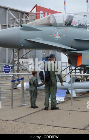 Airshow di Farnborough 2016. Adulto e bambino, eventualmente padre e figlio, ispezione di RAF Typhoon jet da combattimento aereo. Carriera Foto Stock