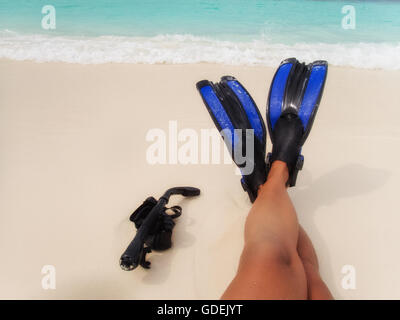 La donna è la gamba di indossare pinne sulla spiaggia, Maldive Foto Stock