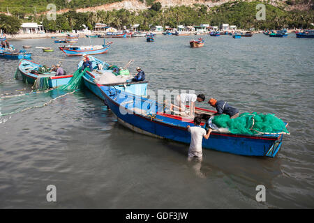 I pescatori lo scarico delle loro catture di pesca dalla barca, Vinh Hy Bay, Mar del Sud della Cina, Vietnam Foto Stock