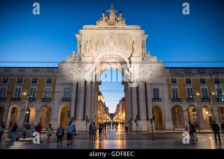 Arco da Rua Augusta Commerce Square Lisbona Portogallo // LISBONA, Portogallo — l'Arco da Rua Augusta si erge illuminato al crepuscolo sulla piazza del commercio nella capitale del Portogallo. L'arco trionfale, completato nel 1873, funge da grande ingresso a Rua Augusta, una delle principali arterie pedonali di Lisbona. Il monumento neoclassico presenta sculture allegoriche che rappresentano Gloria, Ingenuità e Valor, sormontate da figure di Viriato e Vasco da Gama che fiancheggiano una rappresentazione femminile della Gloria. Piazza del commercio, conosciuta localmente come Terreiro do Paco, si trova lungo il fiume Tago nel Bai di Lisbona Foto Stock
