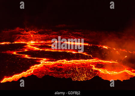 Incandescente il lago di lava con eruzioni di notte, il cratere del vulcano attivo vulcano Erta Ale, Danakil depressione di Afar, Triangolo, Etiopia Foto Stock