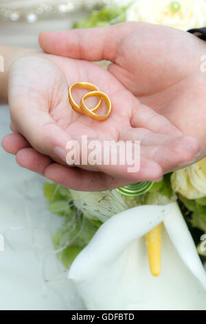 Le mani di una sposa e lo sposo, gli anelli di nozze Foto Stock