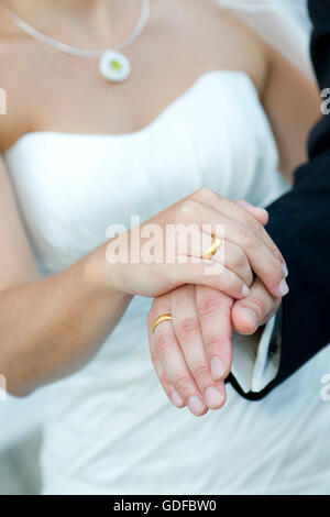 Le mani di una sposa e lo sposo, gli anelli di nozze Foto Stock