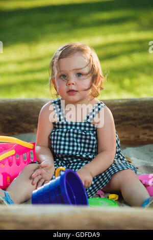 La piccola bambina gioca giochi in sabbia Foto Stock