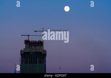 Wien, Vienna: la costruzione della torre blocco DC ( Donau City ) Torre 1, gru da cantiere, luna piena, Austria, Wien, 22. Foto Stock