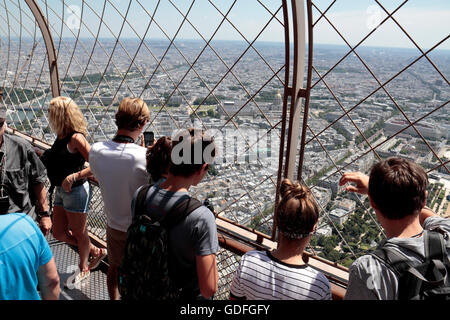 I turisti ammirando la vista verso Les Invalides sul livello superiore di calpestio della Torre Eiffel a Parigi, Francia. Foto Stock