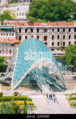 La gente che camminava sul ponte della pace è un arco a forma di ponte pedonale oltre il fiume Kura a Tbilisi, capitale della Georgia. Il Foto Stock