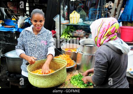 Ragazze malgasce preparare verdura nel mercato Analakely, Antananarivo, Madagascar Foto Stock