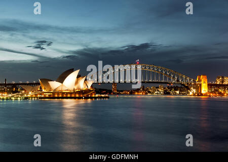 Il Porto di Sydney con la Opera House e Harbour Bridge nella luce della sera. Foto Stock