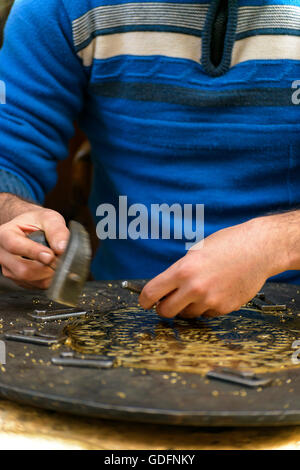 Due Mani di artigiano incisione decorativa capolavoro in ottone Foto Stock