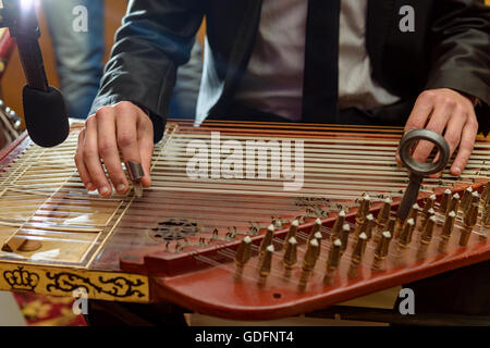 Mani maschio giocando Arabian Qanon strumento musicale durante una sinfonia Foto Stock