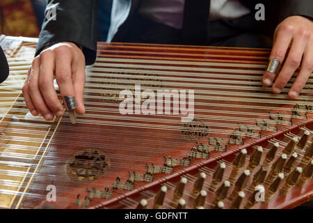 Dita giocando Arabian Qanon strumento musicale durante una sinfonia Foto Stock