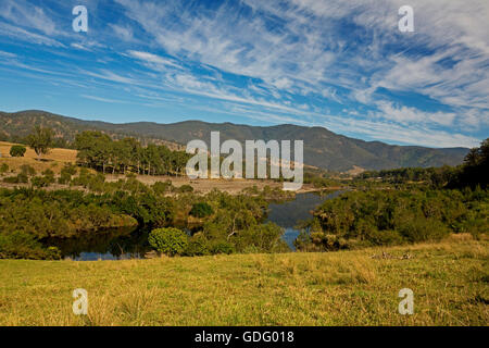 Panorama mozzafiato, Mann affettatura del fiume attraverso i boschi, golden erbe, le colline boscose di Gran Catena Divisoria sotto il cielo blu NSW Australia Foto Stock
