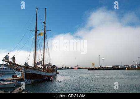 L'Islanda, Nord Europa: una nave a vela nel porto di Husavik, una cittadina di pescatori sulla costa nord dell'isola e un famoso whale watching center Foto Stock