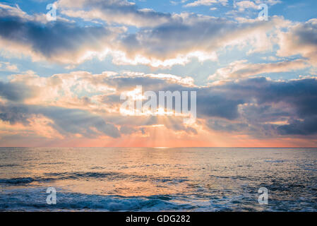 Bellissimo tramonto sul mare. Raggi di sole rompere attraverso le nuvole. Foto Stock
