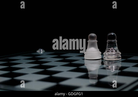 Scacchi di cristallo pezzi su una riga .su sfondo nero. Foto Stock