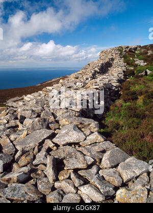 Parapetto muro & a piedi su NW stalattite bastioni di Tre'r Ceiri hillfort (città di giganti), Gwynedd, un'età del ferro & Roman-periodo fortezza. Foto Stock