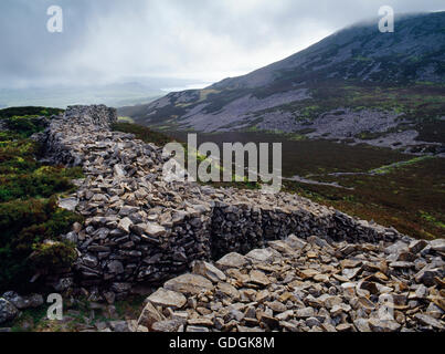 Visualizzare WSW del bastione interno & main (NW) ingresso di tre'r Ceiri hillfort, (città di giganti), Lleyn Peninsula, con picco centrale di Yr Eifl a R. Foto Stock