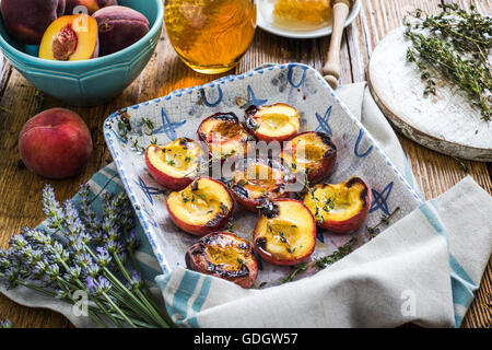 Pesche al forno con il miele e il timo nel vassoio vintage Foto Stock