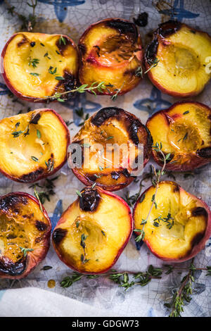 Pesche al forno vicino fino nel vassoio di alimentazione con il timo Foto Stock