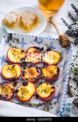 Pesche al forno vicino fino nel vassoio di alimentazione con il timo Foto Stock