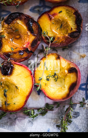 Pesche al forno vicino fino nel vassoio di alimentazione con il timo Foto Stock