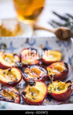 Pesche al forno vicino fino nel vassoio di alimentazione con il timo Foto Stock