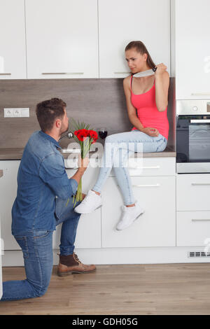 L uomo si chiede per la mano di una donna nel momento sbagliato. La donna non concorda e minaccia il ragazzo con un coltello. Foto Stock