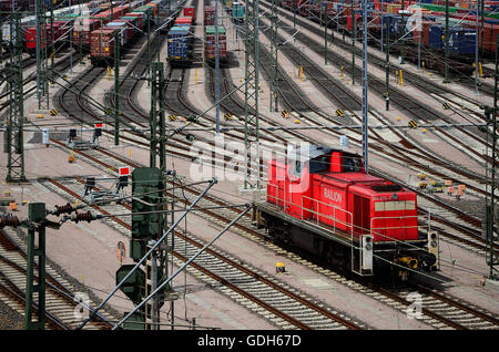 Locomotiva rossa, nel retro contenitori sulle piste, cantiere ferroviario Maschen, Seevetal, Bassa Sassonia, Germania Foto Stock